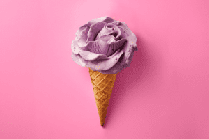 Image: Lavender and Honey purple ice cream in the shape of a flower on top of an ice cream cone.